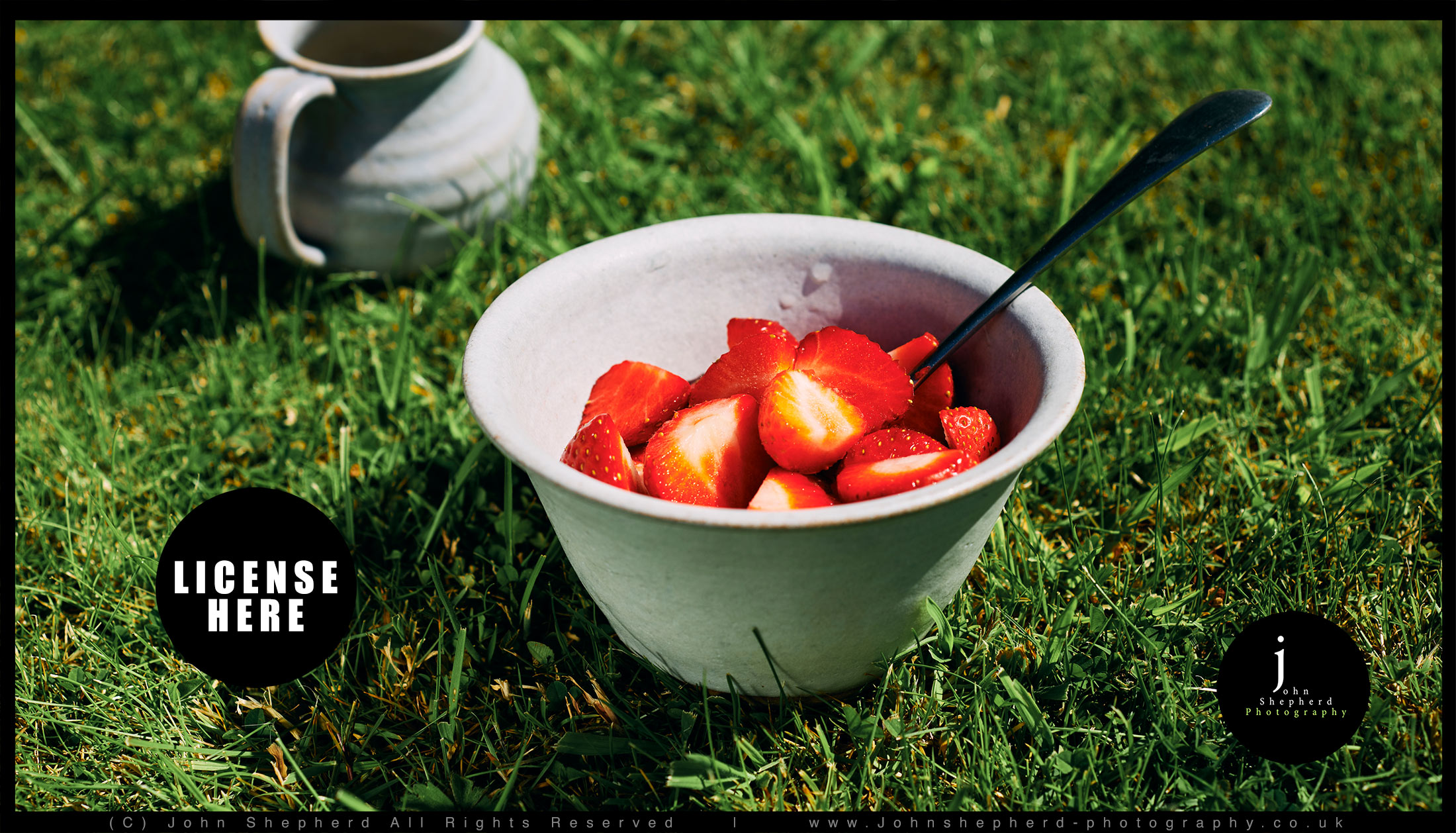 Bowl of strawberries on a summer Lawn.